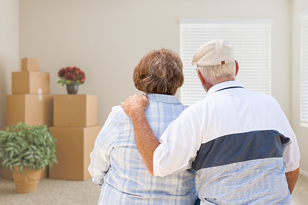 senior couple looking at room with moving boxes