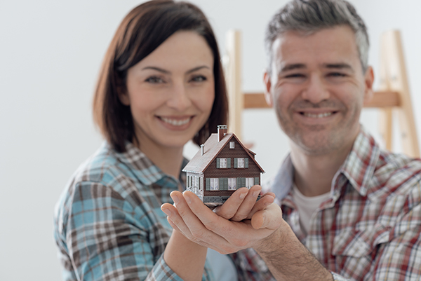 couple holding miniature house model