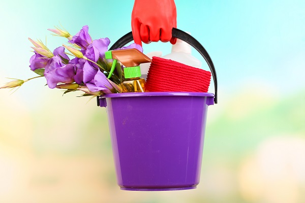 bucket with cleaning products and flowers
